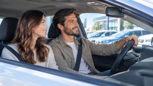 pareja manejando auto nuevo financiado con préstamo prendario